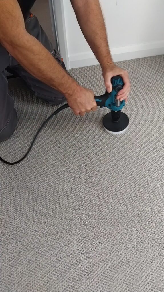 Carpet cleaners’ handheld tool on a grey carpet